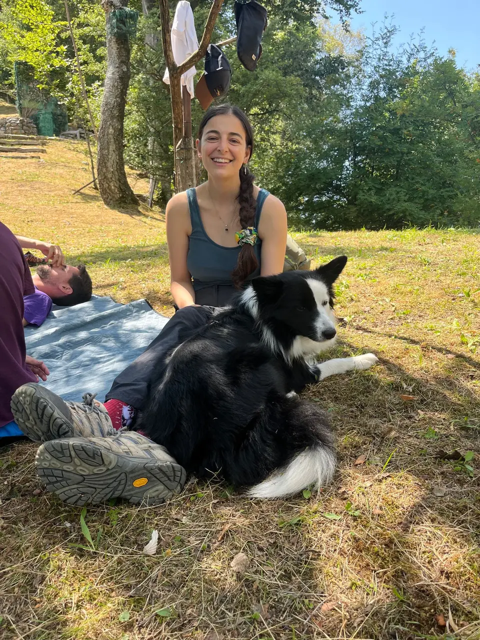 Meg sorride seduta sull’erba accanto a Gea durante una pausa.